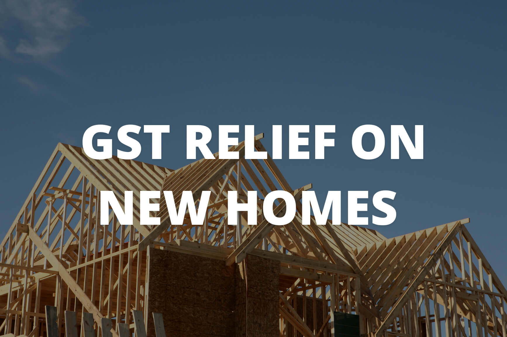 Wooden frame of a house under construction with a clear blue sky in the background. Bold white text over the image reads “GST RELIEF ON NEW HOMES.”.