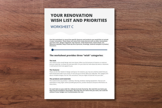 A renovation worksheet titled Your Renovation Wish List and Priorities rests on a wooden surface. The sheet is labeled Worksheet C and contains text about organizing renovation ideas into three categories.