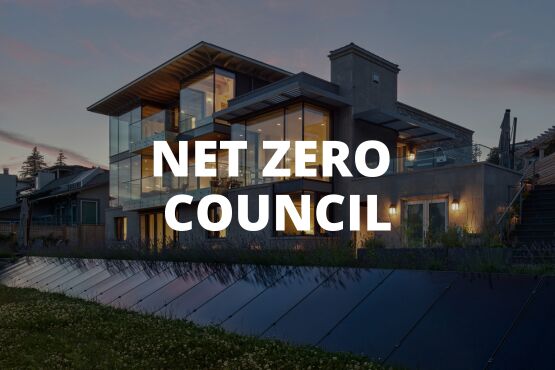 Modern house with large windows at dusk, solar panels in the foreground, and the words NET ZERO COUNCIL prominently displayed over the image.
