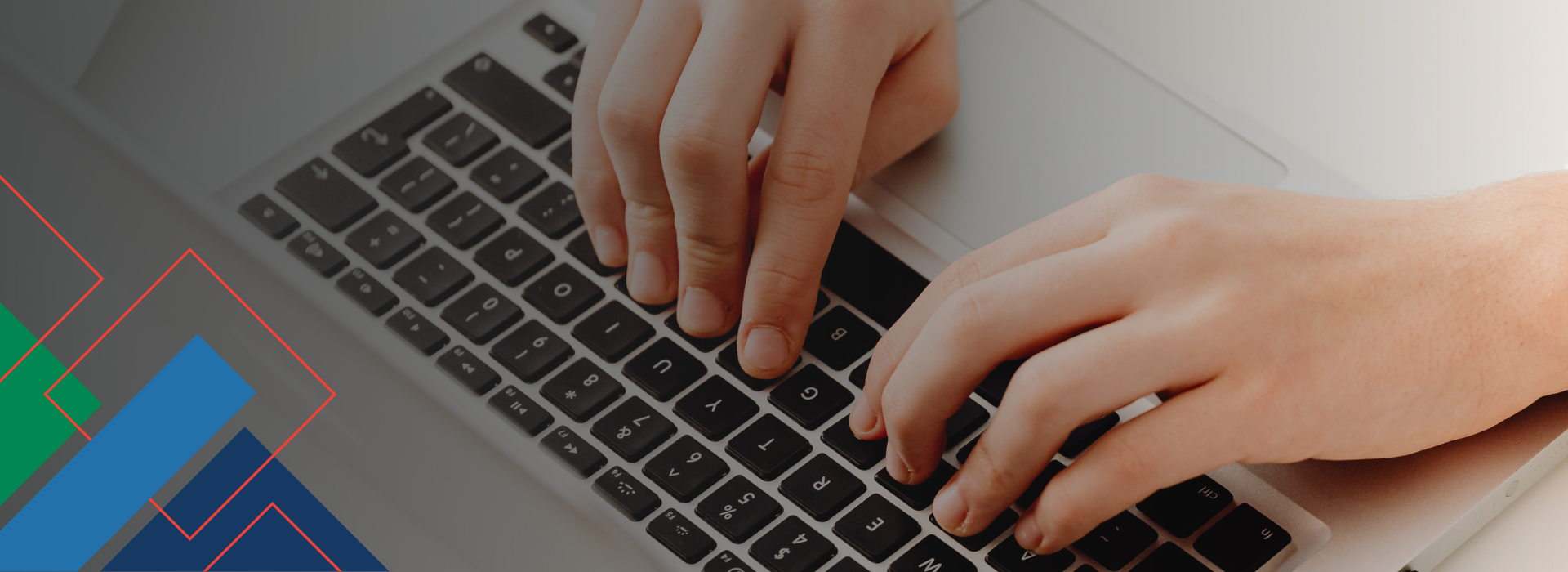 Hands typing on a laptop keyboard, with geometric colored lines in the bottom left corner of the image, evoking the innovative spirit of the Canadian Home Builders’ Association.
